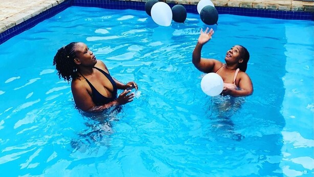 A swimming pool with two people playing with balloons. - Airport Royal Guest House (Kempton Park)