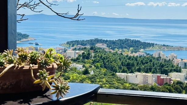 Ein Balkon mit Blick auf eine Küstenstadt, einschließlich Gebäude und eines Gewässers.