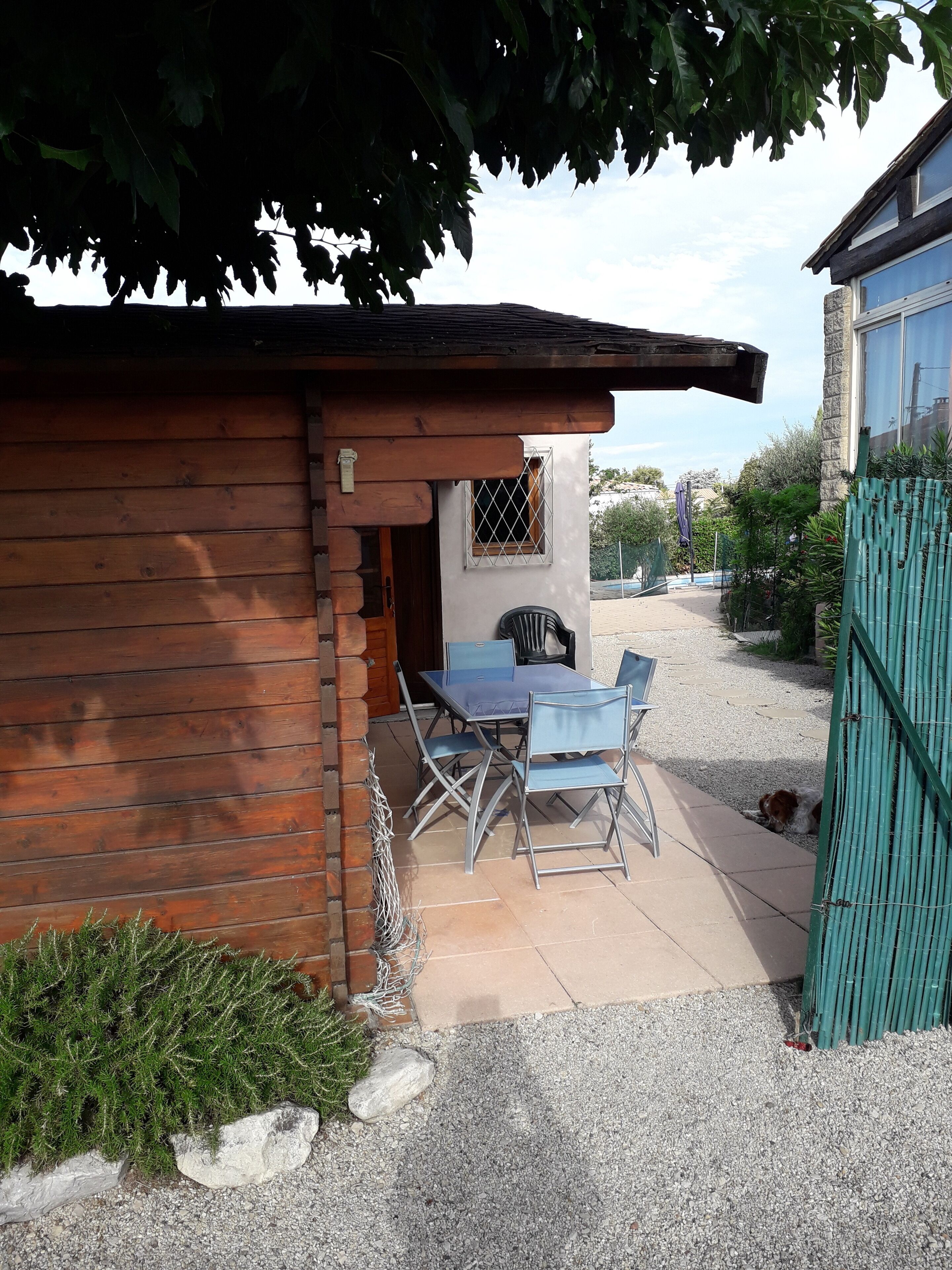 Een houten vakantiehuis met een terras, een tafel en stoelen.