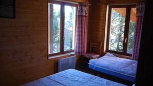A cabin room with two beds, a chair, and large windows with curtains. - 4 **** CHALET WITH TOURISM CLASSIFICATION  (Les Angles)