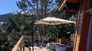 A wooden deck with outdoor furniture, including a table and chairs, and a barbecue grill. - 4 **** CHALET WITH TOURISM CLASSIFICATION  (Les Angles)