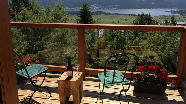 A wooden deck with two chairs and a table, overlooking a lake and mountains. - 4 **** CHALET WITH TOURISM CLASSIFICATION  (Les Angles)
