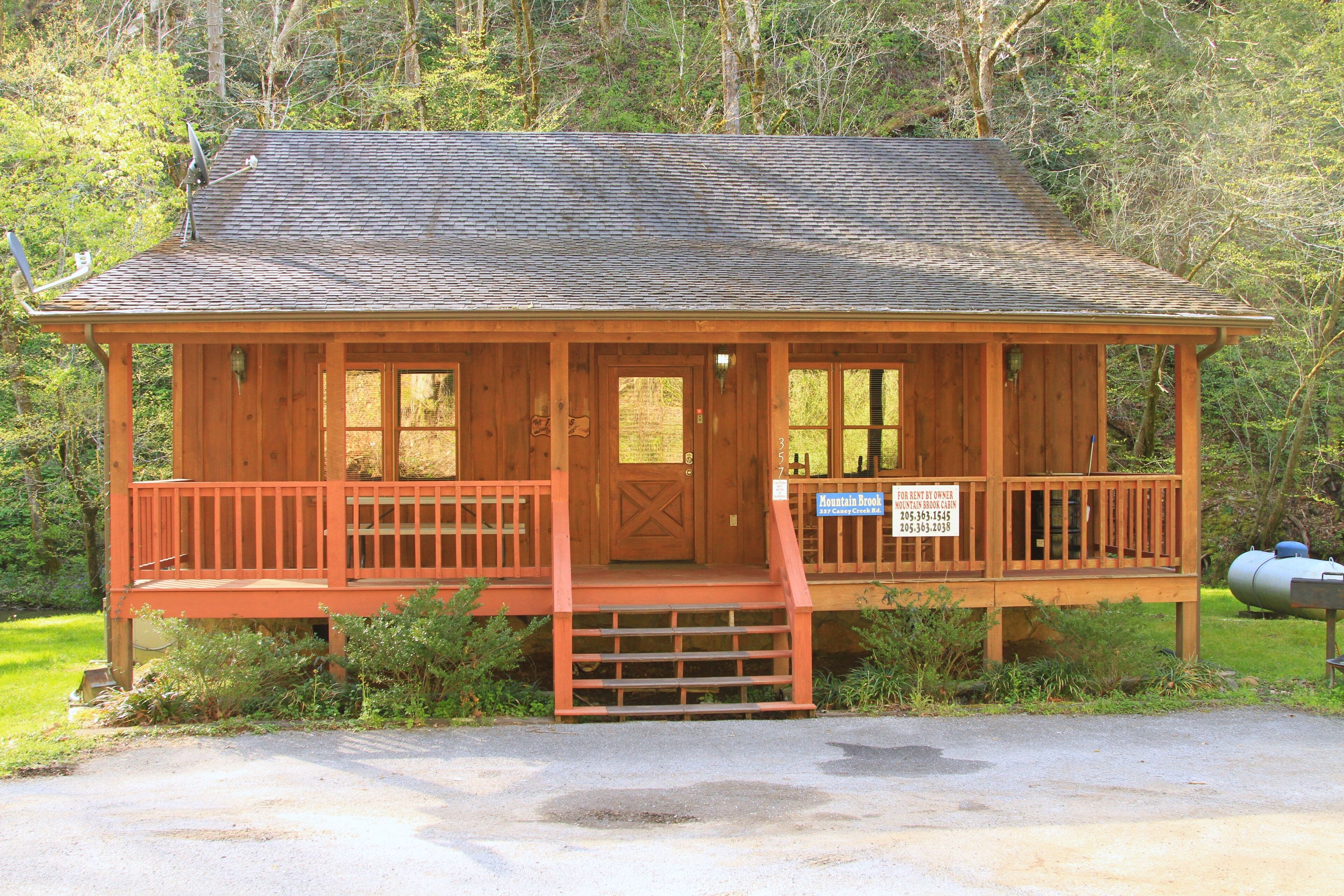 A wooden cabin with a porch, a door, and a sign indicating it is for rent.