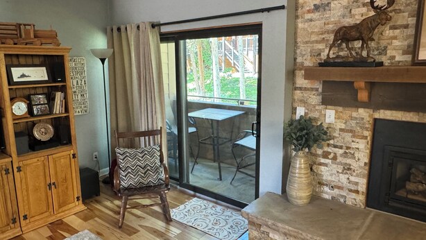 Sala de estar con un aparador de madera, una silla, chimenea y vistas al exterior.