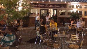 Een buitenzitgedeelte met tafels en stoelen bij St Roch Market.