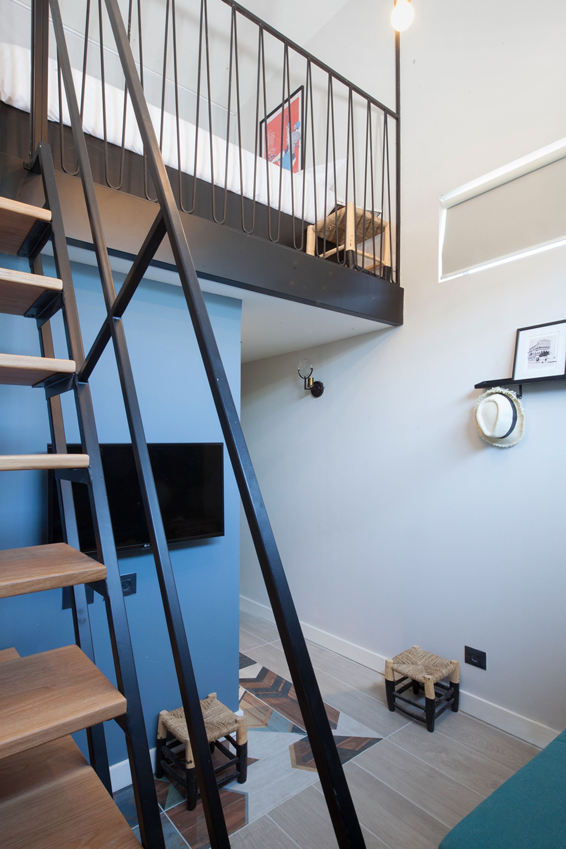 A modern staircase with black railings leading to a lofted area.