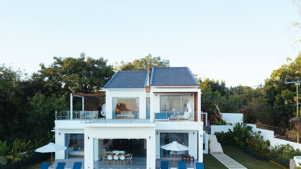 A modern two-story house with a swimming pool, outdoor seating, and a balcony. - Modern Oceanfront Luxury in the Unspoilt Beauty of the Original Bali (Seririt)