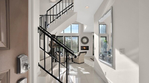 Ein modernes Interieur mit Treppe, Kamin und großen Fenstern.