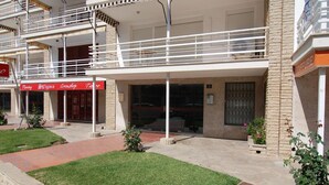 Een gebouw met twee verdiepingen, voorzien van een overdekte ingang en een bord waarop staat: "Piercing Stigma Crownshop".