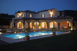 A two-story stone house with a swimming pool, outdoor seating, and a well-lit patio area. - Luxury villa with large heated pool and game room (Motovun)