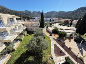A residential area with modern buildings, a central courtyard, and surrounding hills.