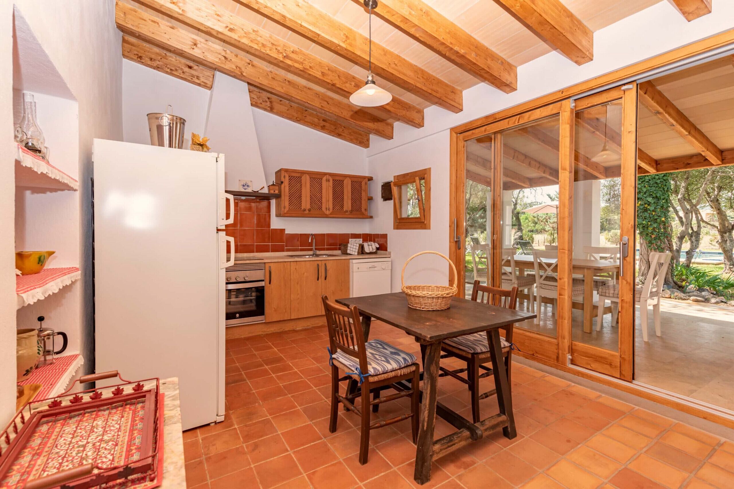 A kitchen with wooden cabinets, a white refrigerator, and a dining table with chairs.