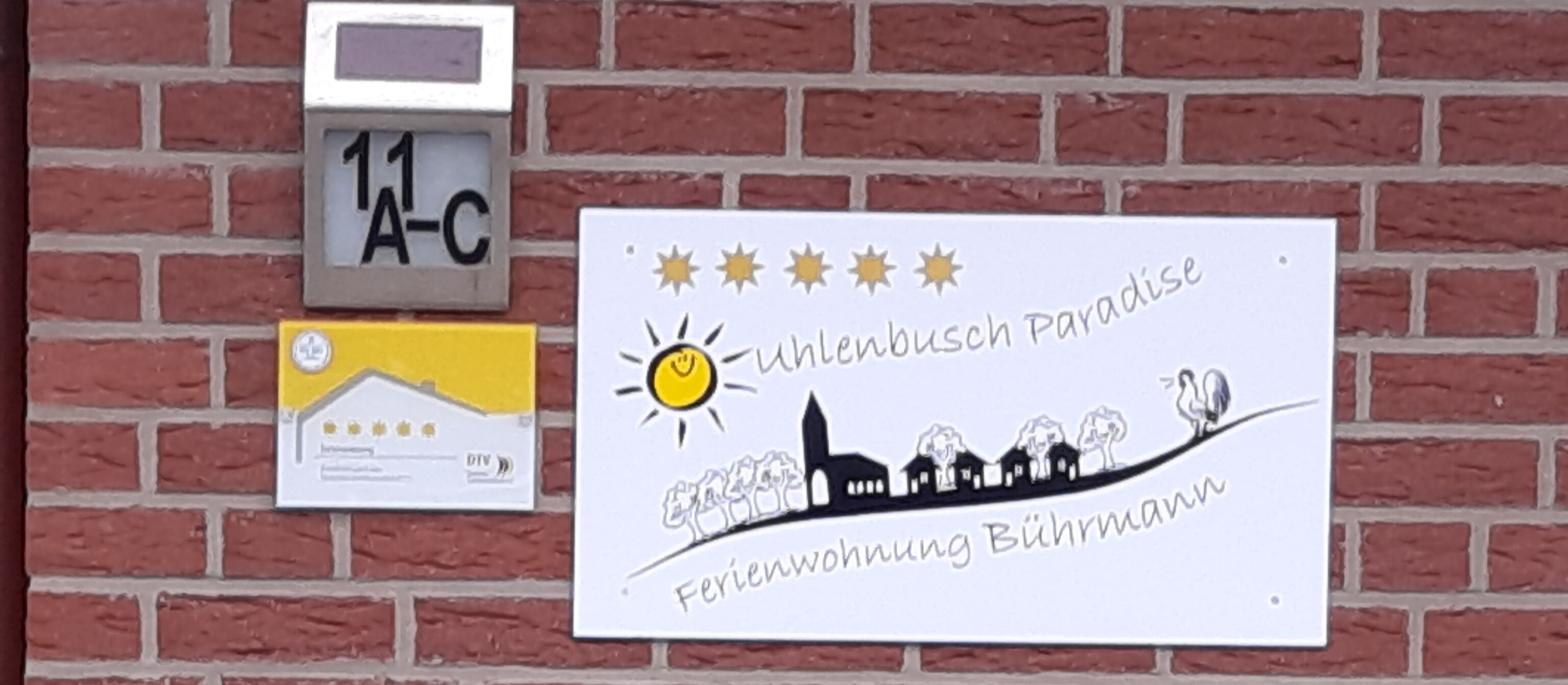 A sign with a sun and a cityscape, and a small clock above it.