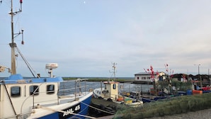Un puerto con barcos amarrados, un edificio al fondo y un cielo despejado.