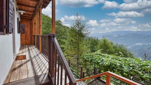 Ein hölzerner Balkon mit Blick auf eine Berglandschaft.