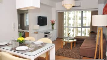 Un apartamento de dos dormitorios con comedor, sala de estar y un gran ventanal con cortinas.