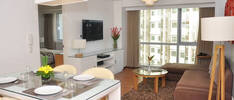 A 2-bedroom apartment with a dining area, a living room, and a large window with curtains.