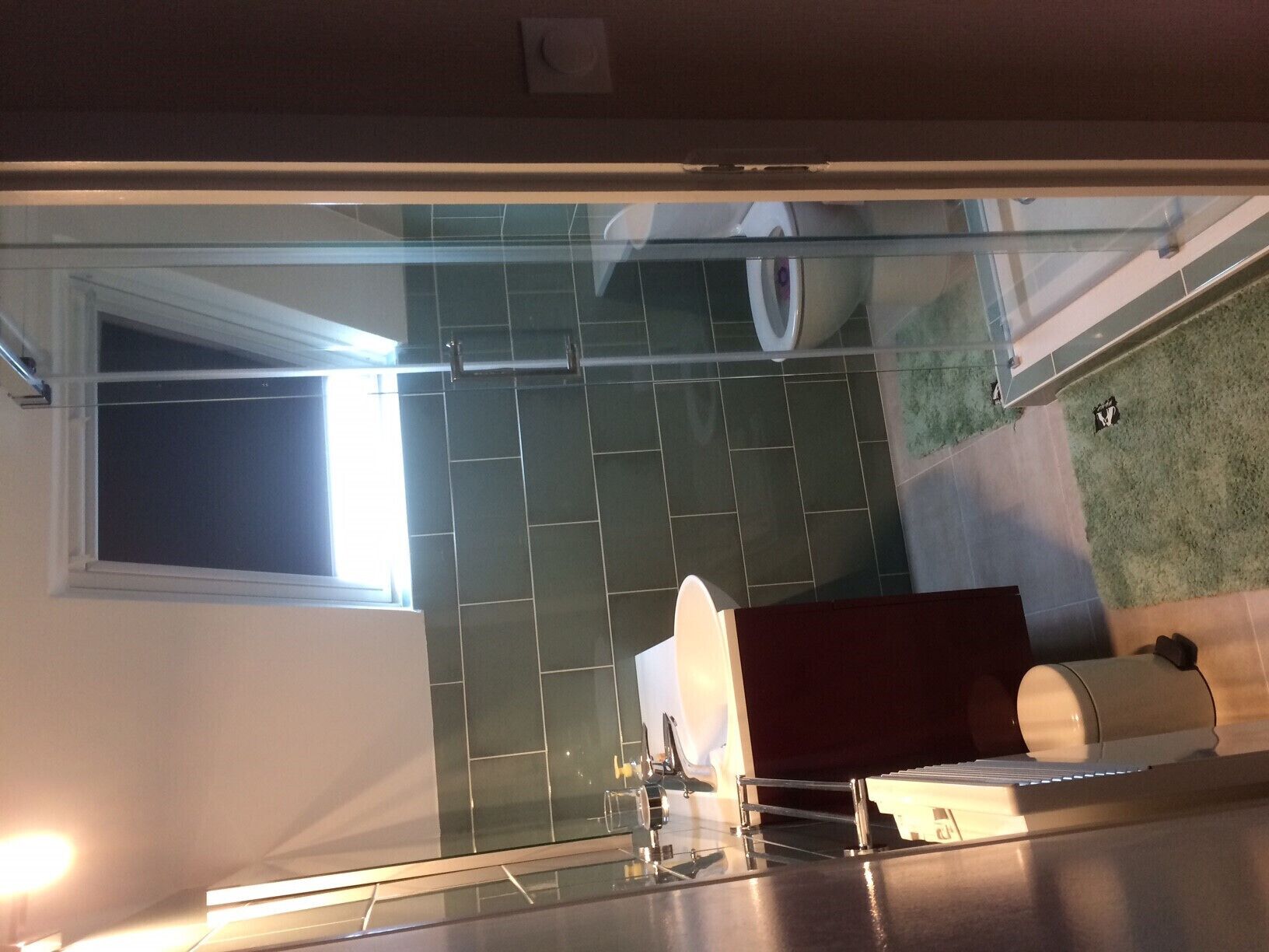 Un bany modern amb una dutxa de vidre, un vàter i una zona de bany.