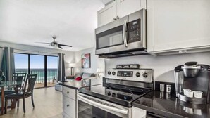 A modern kitchen with a built-in microwave, oven, and coffee maker.