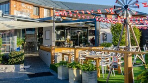 Un hotel con terraza al aire libre, un molino y un cartel que indica un precio de 18.