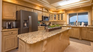 A modern kitchen with granite countertops, stainless steel appliances, and wooden cabinetry. - Gorgeous 4900 square foot pool & spa home minutes from Lake Travis and winery (Marble Falls)