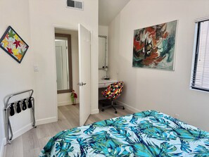 A bedroom with a bed, a desk, a chair, a mirror, and artwork on the walls. - 4 Bdrm Private Jungle House, minutes to all, patios, fire pit,  parking, trees! (San Diego)
