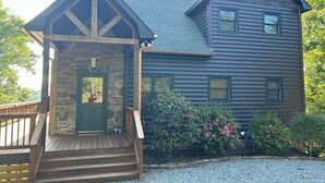 A log cabin with a stone entrance and a wooden porch. - Cozy Getaway Long Range View Paved Access Minutes To Downtown Blue Ridge Hot Tub (Blue Ridge)