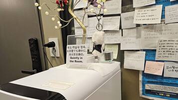 A room with a Cuckoo printer, a wall with various notes and a cat illustration, and a door labeled '510'.