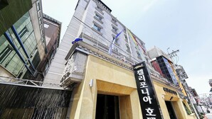 Un hotel con fachada moderna, que destaca un letrero negro con letras blancas.