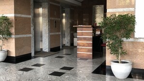 A modern lobby with marble flooring, a reception desk, and potted plants. - Hedges Court Residencies Town Hall-2 Room 3 Bed Apartment (Colombo)