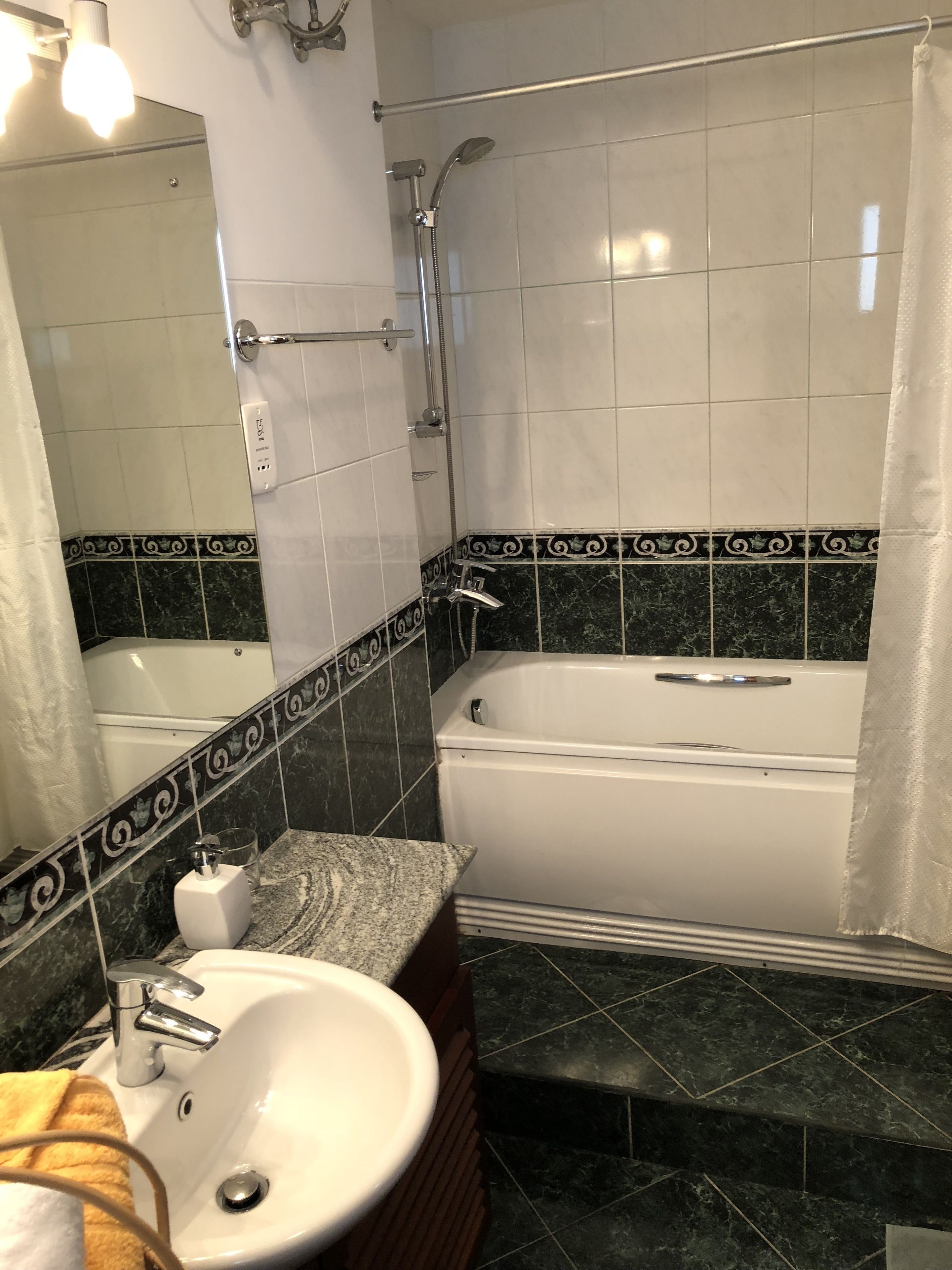 Une salle de bain avec une baignoire blanche, un lavabo et une douche.
