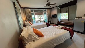 Habitación de hotel con dos camas, ventilador de techo, televisor y vistas al exterior.