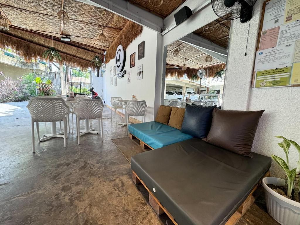 A room with a sofa, chairs, a table, and a ceiling fan.