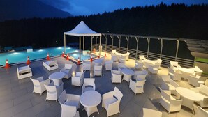 Un espace extérieur aménagé avec des tables et des chaises, une piscine et une tente.