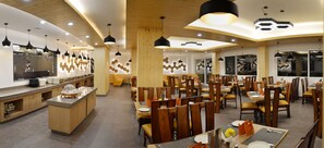 Un restaurante moderno con mobiliario de madera, iluminación colgante y una isla central.