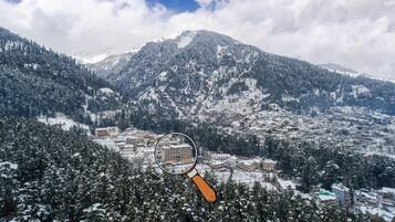 A mountainous landscape with snow-covered trees and buildings.