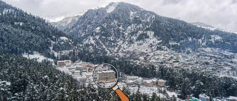 A mountainous landscape with snow-covered trees and buildings.