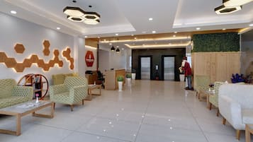 A modern reception area with hexagonal wooden wall decor, a reception desk, and seating arrangements.