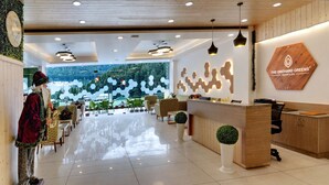Un hall d’hôtel moderne doté d’un comptoir d’accueil, d’un espace salon et offrant une vue sur l’extérieur.