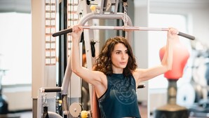A person using a gym machine with various attachments and weights. - Capella Otel (Eskisehir)