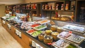 A buffet with various food items and condiments. - Capella Otel (Eskisehir)