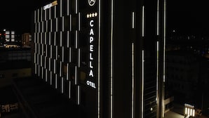 The exterior of the Capella Hotel at night, featuring vertical light strips and a star rating sign. - Capella Otel (Eskisehir)