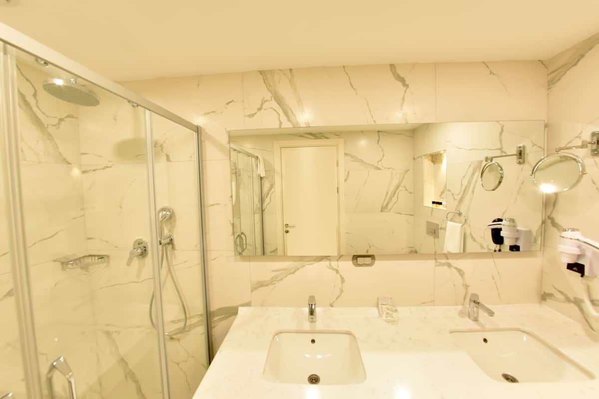 family suite, 1 king bed, non smoking, city view | bathroom | designer toiletries, hair dryer, slippers, towels