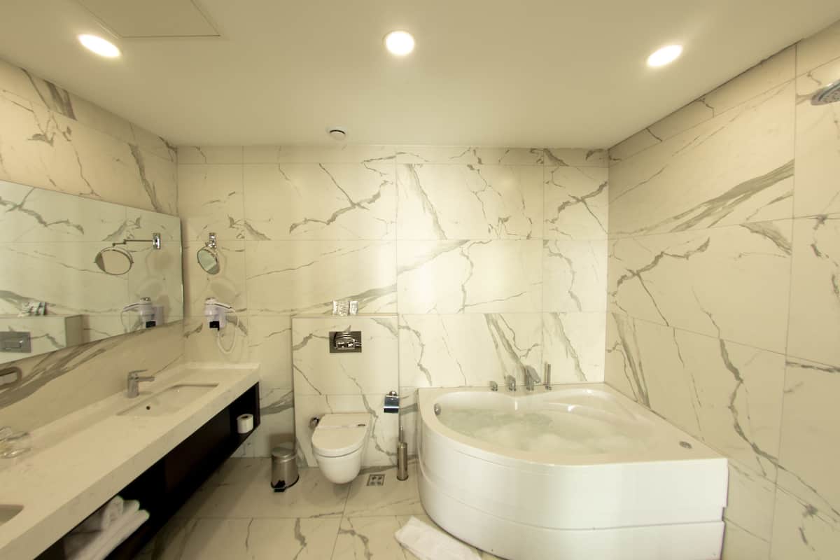 executive suite, 1 bedroom, non smoking, city view | bathroom | designer toiletries, hair dryer, slippers, towels