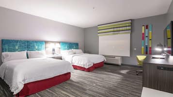 A hotel room with two beds, a desk, a chair, and a large window with a view.