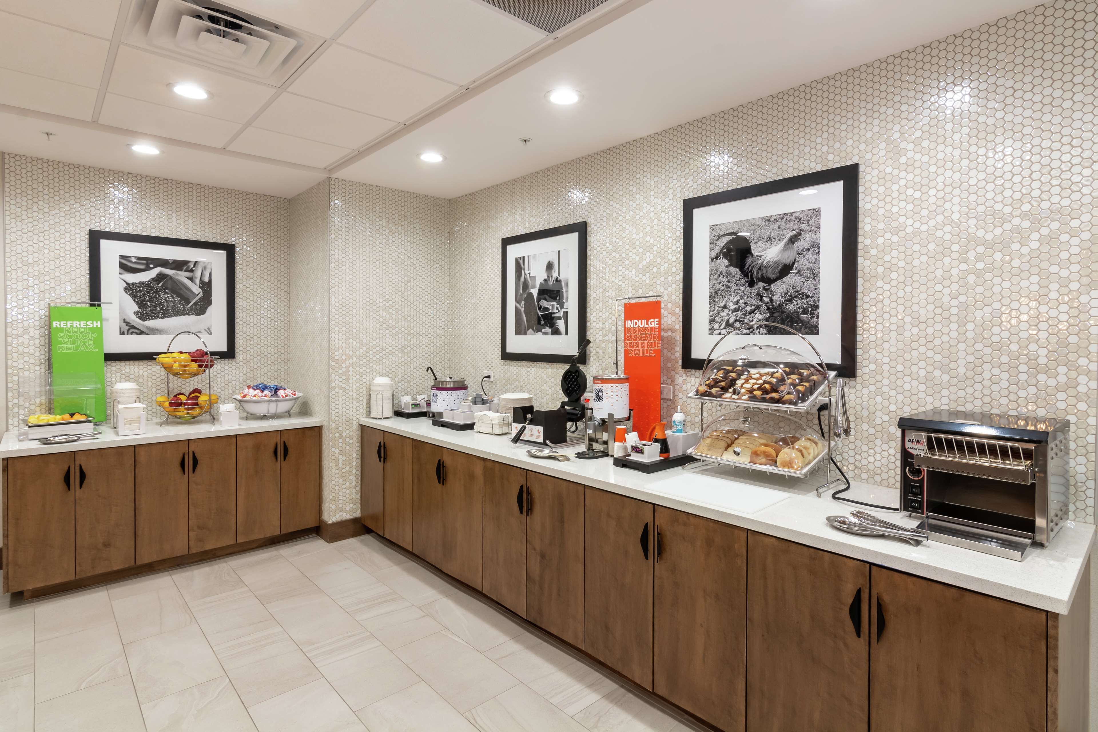 Una cuina d'hotel amb un dispositiu de bufet, incloent una estació de cafè, una torradora i una presentació de productes de forneria.