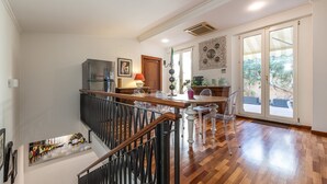 Una cocina amplia con una isla de madera, un refrigerador y un comedor con sillas.