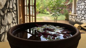 A traditional stone wall and a wooden door leading to a garden. - Plumeria Luxury Villas (Udawalawa)