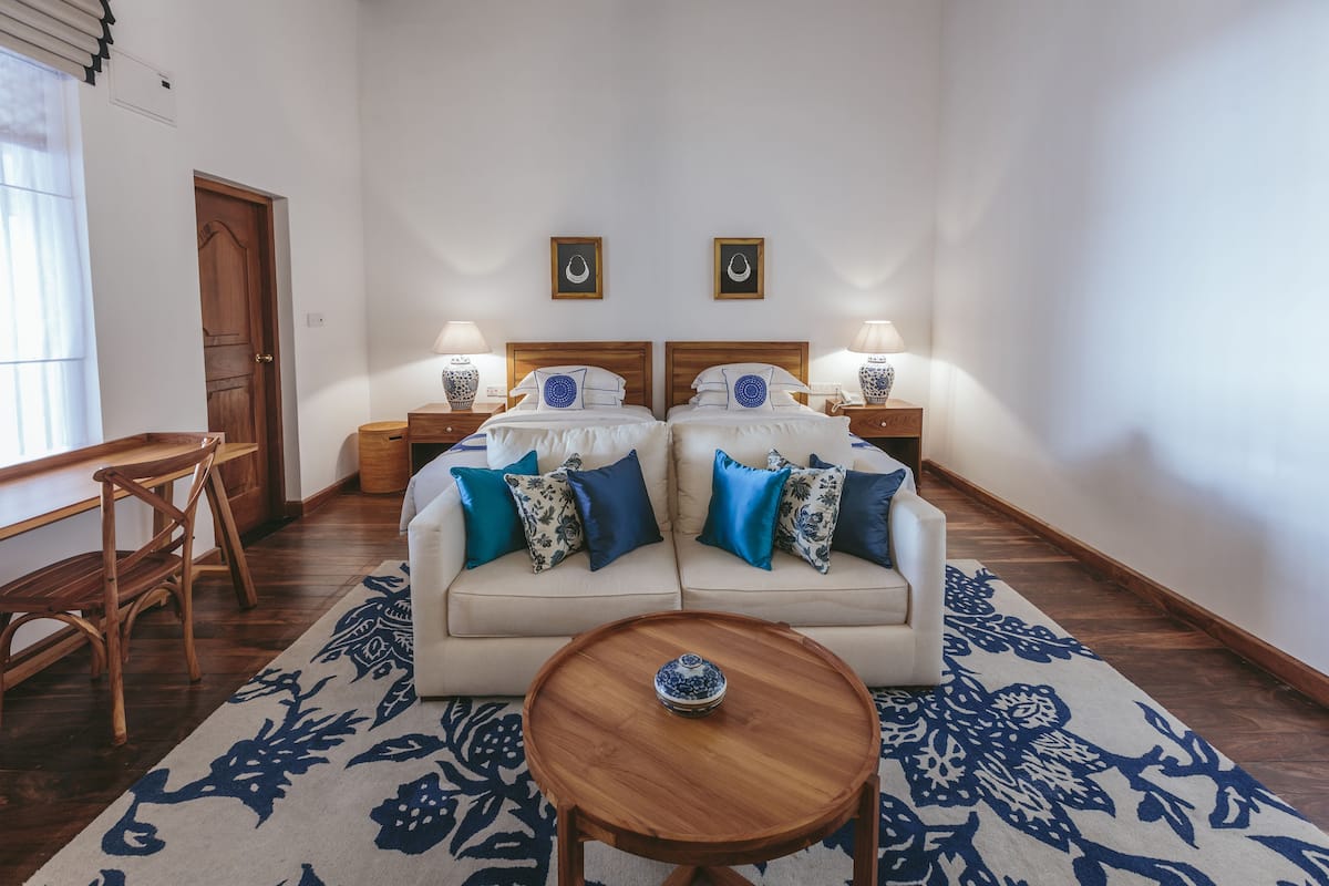 Une pièce comprenant un ensemble de canapés, deux tables de chevet avec des lampes, une table basse en bois et un tapis à motifs.