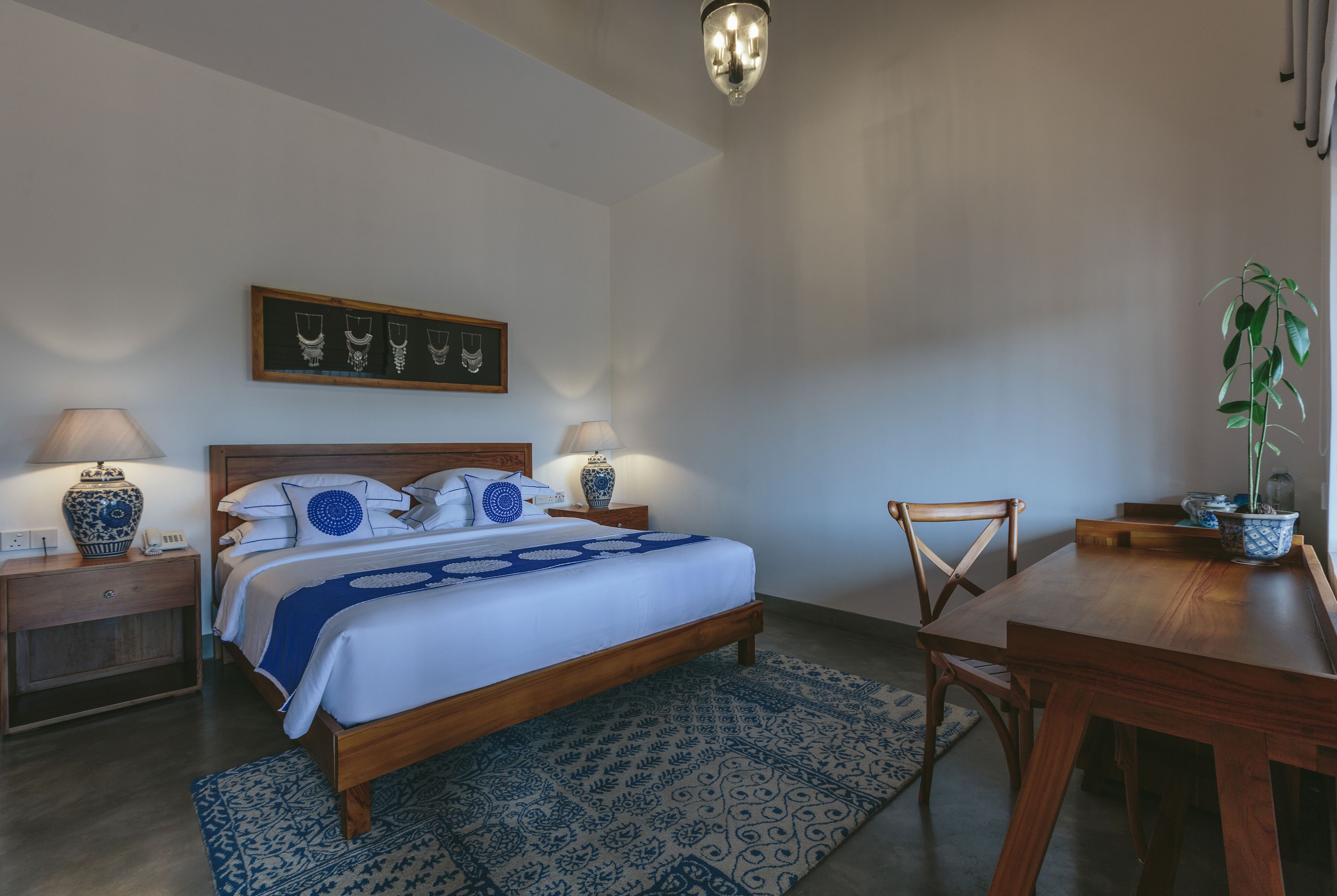 Un dormitorio con cama, mesitas de noche, un escritorio y una silla.